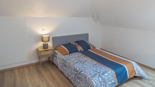 a bedroom with a bed and a night stand with a lamp at L'Échappée Belle des Riceys - 6 pers in Les Riceys