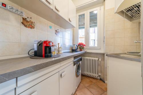 a kitchen with a sink and a washing machine at Antico Borgo in Borgo San Dalmazzo