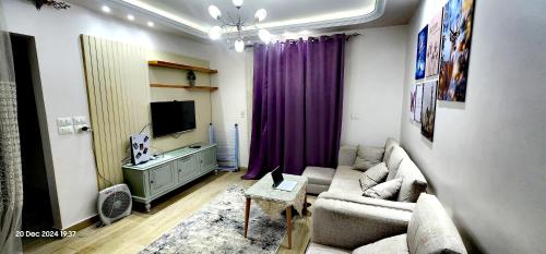 ein Wohnzimmer mit Sofa und Fernseher in der Unterkunft Gardenia City 652-1 in Kairo