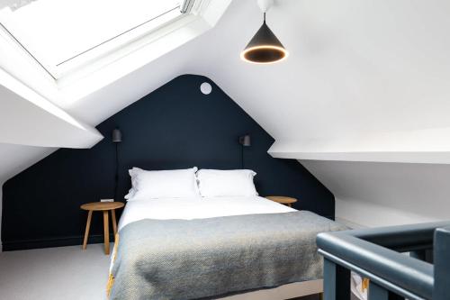 ein Schlafzimmer mit einem Bett mit einer schwarzen Wand in der Unterkunft A Beautiful 3 Bedroom 17th Century Stone cottage in Llanddyfnan