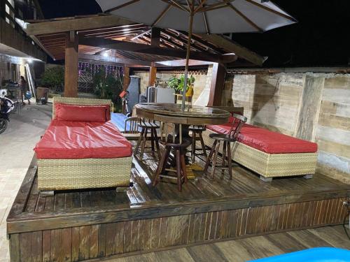a patio with a table and chairs and an umbrella at Recanto CostaCastilho in Bertioga