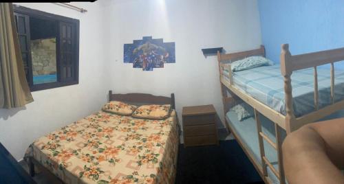 a bedroom with two bunk beds and a bed at Recanto CostaCastilho in Bertioga