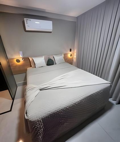 a bedroom with a large bed with white sheets at Get By Side in João Pessoa