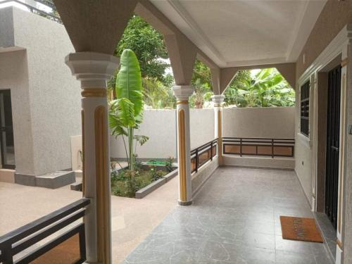 a porch of a house with columns and a fence at Jolie Résidence de 03 chambres salon Légbassito in Atyémé