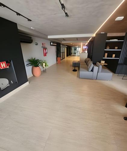 a living room with white furniture and a hallway at Get By Side in João Pessoa