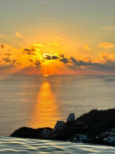 a sunset over the ocean with the sun setting at Villa San Sebastian, Los Celajes in Acapulco
