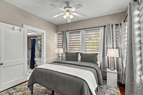een slaapkamer met een bed en een plafondventilator bij Step into the charm of yesteryear with the modern comforts of today at City Cottage! in Sarasota