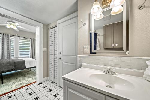 een badkamer met een wastafel en een spiegel bij Step into the charm of yesteryear with the modern comforts of today at City Cottage! in Sarasota