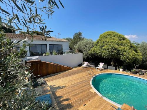une arrière-cour avec une terrasse en bois et une piscine dans l'établissement La marjolaine, à Aubagne