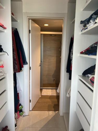 a walk in closet with a door leading to a bathroom at Dpto de playa 2 dormitorios Aqua Village Sanber in San Bernardino