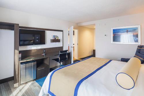 a hotel room with a bed and a flat screen tv at Southbank Hotel Jacksonville Riverwalk in Jacksonville