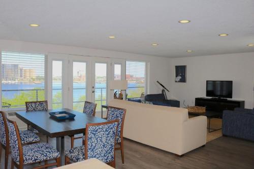 a living room with a table and chairs and a television at Southbank Hotel Jacksonville Riverwalk in Jacksonville