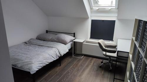 ein kleines Schlafzimmer mit einem Bett, einem Schreibtisch und einem Stuhl in der Unterkunft 7 stars in Środa Śląska