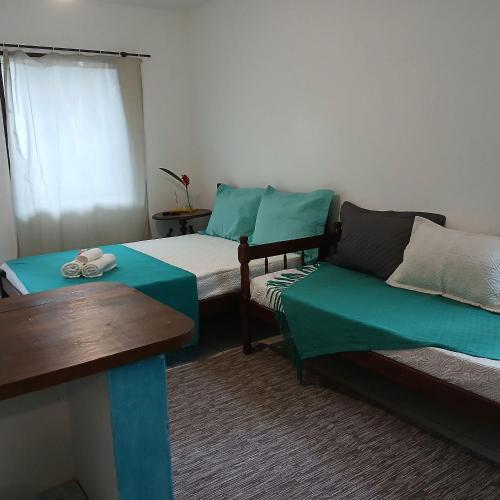 a room with two beds and a couch and a table at Studio8 Centro Paraty in Paraty