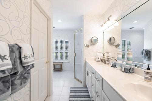 a white bathroom with a sink and a mirror at 316 Marco in Marco Island