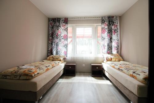 dwa łóżka w pokoju z oknem w obiekcie Ośrodek Wrzos w mieście Boruja