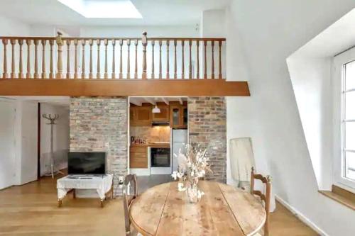 un salon avec une table et un escalier dans l'établissement Chez Camille, à Paris