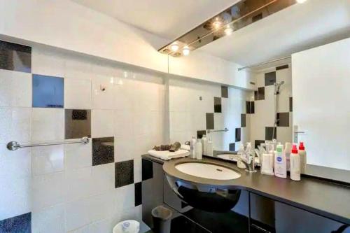 une salle de bain avec un lavabo et un miroir dans l'établissement Chez Camille, à Paris