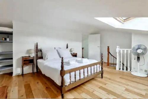 - une chambre avec un lit, un bureau et un ventilateur dans l'établissement Chez Camille, à Paris