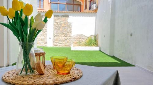 un tavolo con due bicchieri e un vaso con fiori di NanuDomus a Villasimius