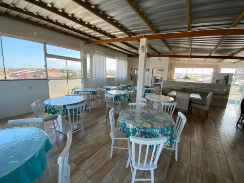 a restaurant with tables and chairs and a piano at Pousada Bella Praia in Torres