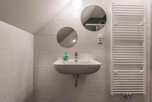 a white bathroom with a sink and a mirror at Ubytování Kroupa in Dolní Dunajovice