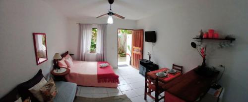 a bedroom with a bed and a living room with a couch at Studio7 Terra prox Centro Paraty in Paraty