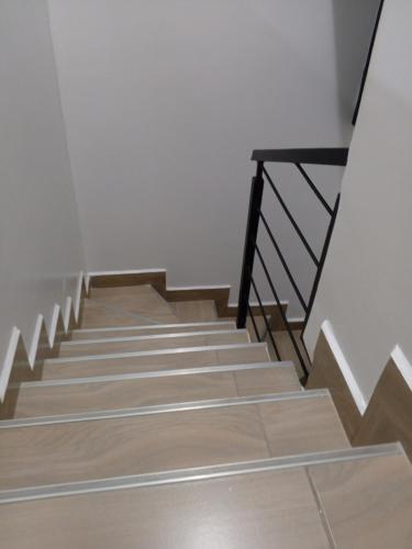 a staircase with wooden floors and a black railing at Perfect Hideaway in Rungiri