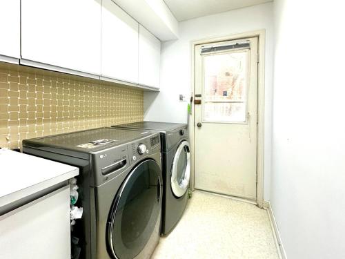 a washing machine in a kitchen with a door at Cozy and spacious vacation home in Toronto in Toronto
