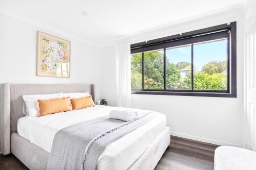 Una cama o camas en una habitación de 6 BDRM I Serenity at Buff Point