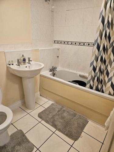 ミルトン・キーンズにあるLux Den close to M1! Netflix , Parking & Broadbandの洗面台、浴槽、トイレを備えたバスルーム