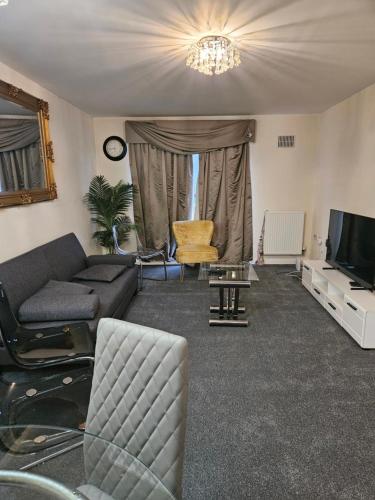 a living room with a couch and a tv at Lux Den close to M1! Netflix , Parking & Broadband in Milton Keynes