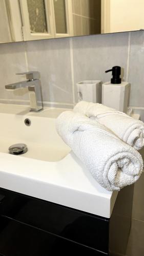 - un lavabo blanc dans la salle de bains avec des serviettes dans l'établissement L'Horacien Plein Cœur de Marseille, à Marseille