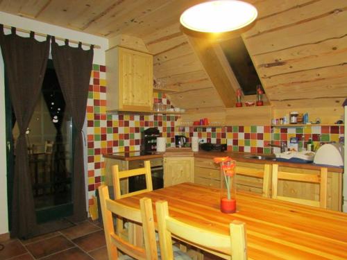 a kitchen with a wooden table with a vase of flowers at Apartmaji Koželj in Ribnica na Pohorju