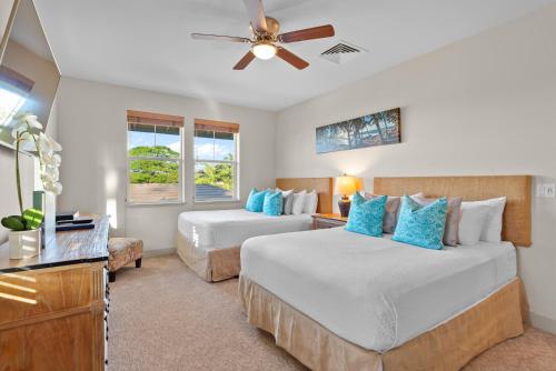 a bedroom with two beds and a ceiling fan at Halii Kai 20D in Waikoloa
