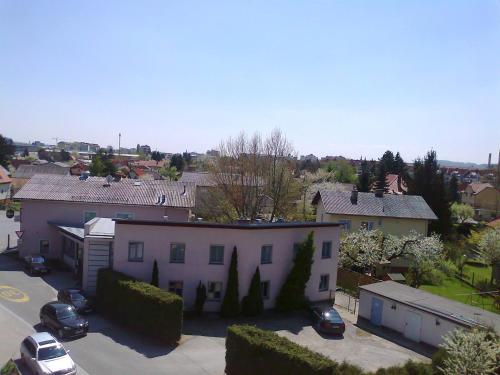a white house with cars parked in a parking lot at Gasthof Bokan in Graz