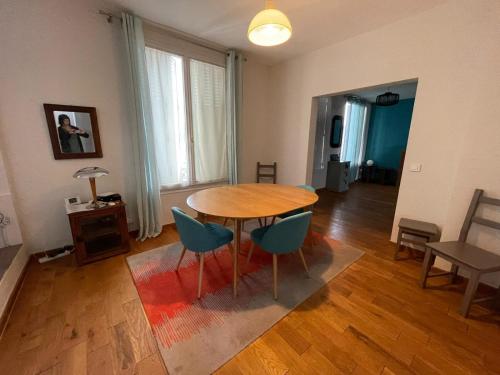 a living room with a wooden table and chairs at Agréable Maison Familiale in Arcueil