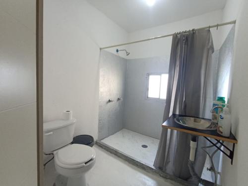 Un baño blanco con inodoro y ducha. en Casa indico, en Cabo San Lucas