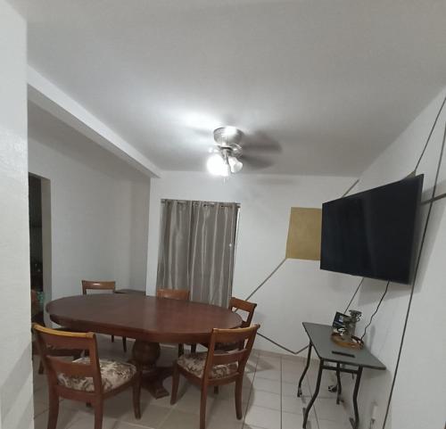 Un comedor con una mesa y un televisor de pantalla plana. en Casa indico, en Cabo San Lucas