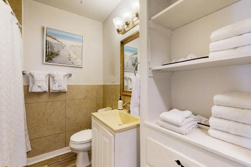 un bagno con lavandino, WC e asciugamani di The Green Cottage a Corpus Christi