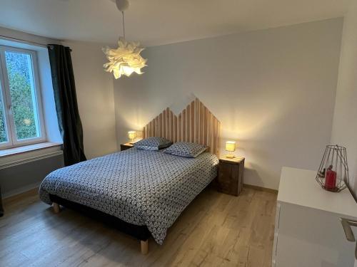 une chambre avec un lit et un lustre dans l'établissement Naturel loft 5 personnes et jardin, à Saint-Maurice-sur-Moselle