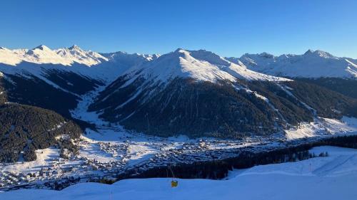 a view of a snowy mountain range with a town at Furnished apartment Davos Platz close to WEF in Davos