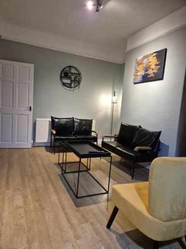 a living room with two couches and a table at The Reddish Retreat in Manchester