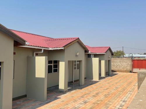 a row of houses with red roof at Cadami apartments in Mazabuka