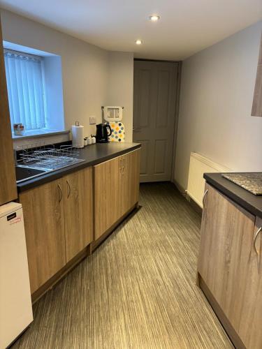a kitchen with wooden cabinets and a counter top at Ground Floor Studio in Longtown