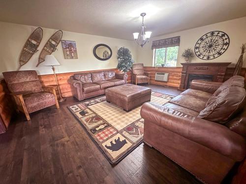 a living room with leather furniture and a fireplace at FairBridge Inn and Suites Sandpoint in Ponderay