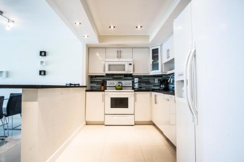 a kitchen with white cabinets and white appliances at Ocean Reserve 927 in Miami Beach