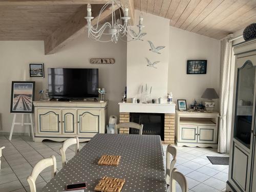 une salle à manger avec une table et une cheminée dans l'établissement Maison de standing style rethais, au Bois-Plage-en-Ré