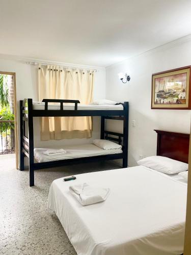 two beds in a room with two bunk beds at Hotel Casa Fátima in Cartagena de Indias