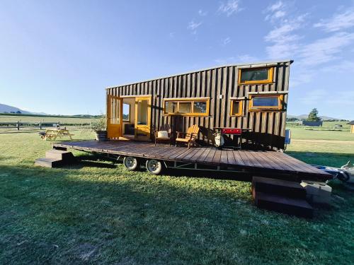 a tiny house on a trailer on a field at Tarras Tiny Haven - Wake up to Breathtaking Mountains in Tarras